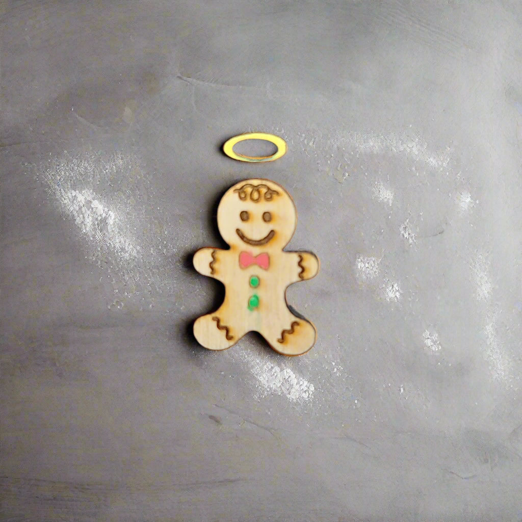 gingerbread angel with bowtie on a baking sheet with flour spots around it.
