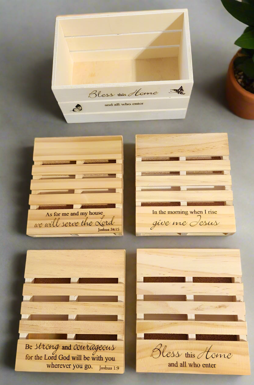 four pallet coasters with cork backing on a counter with a crate nearby with the text 'Bless this home' etched into the front.